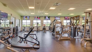 A gym with various exercise machines, large windows, and a ceiling fan. - North Fort Myers Getaway w/ Resort Amenities! (North Fort Myers)