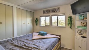 A bedroom with a bed, a wardrobe, a TV, and a window with a view.