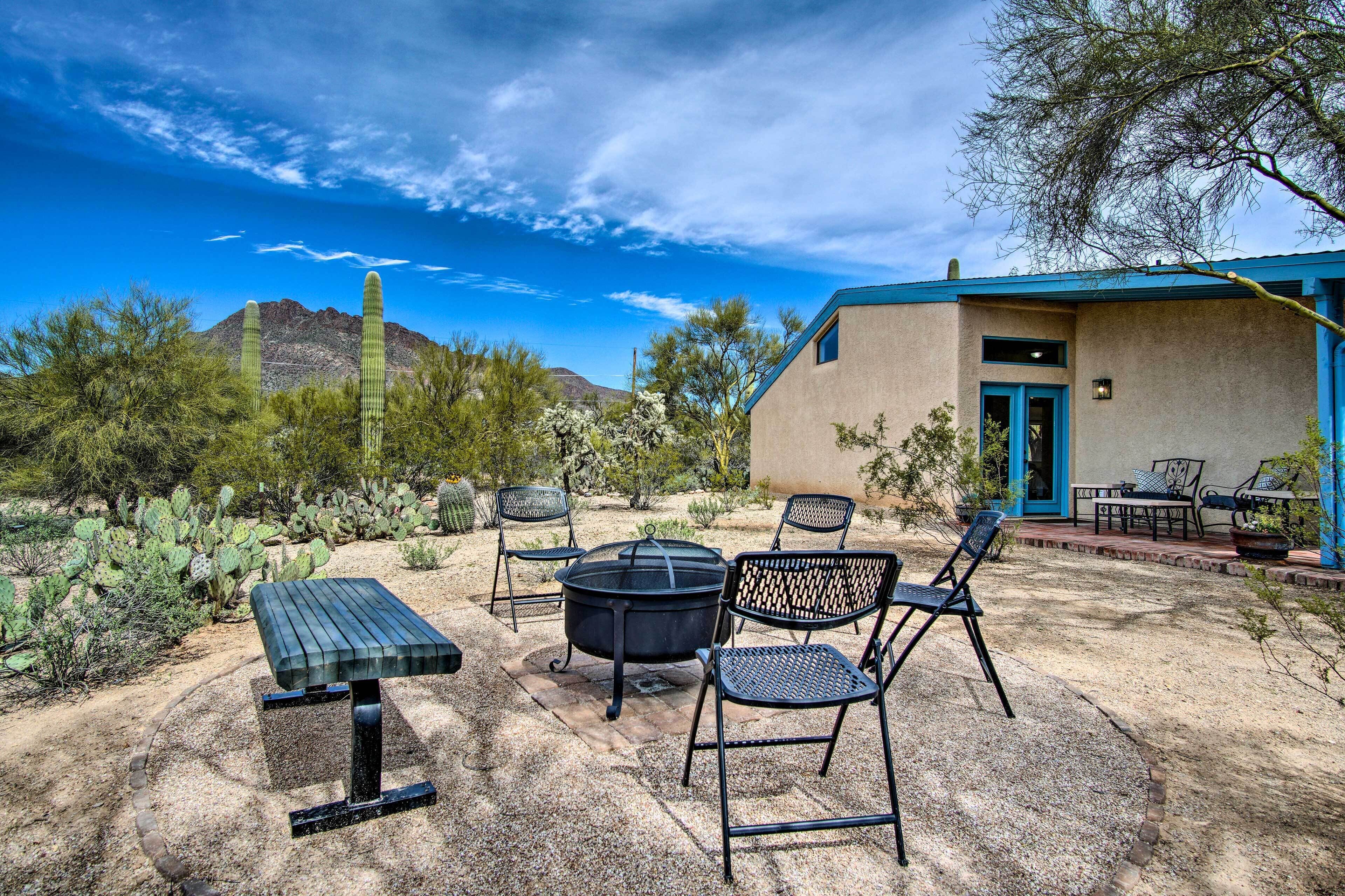 An outdoor patio with a barbecue grill, chairs, and a table.