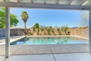 A swimming pool with a clear blue water surface, surrounded by a concrete deck and a pergola structure. - Pool, Patio & Grill: San Tan Valley Escape! (San Tan Valley)