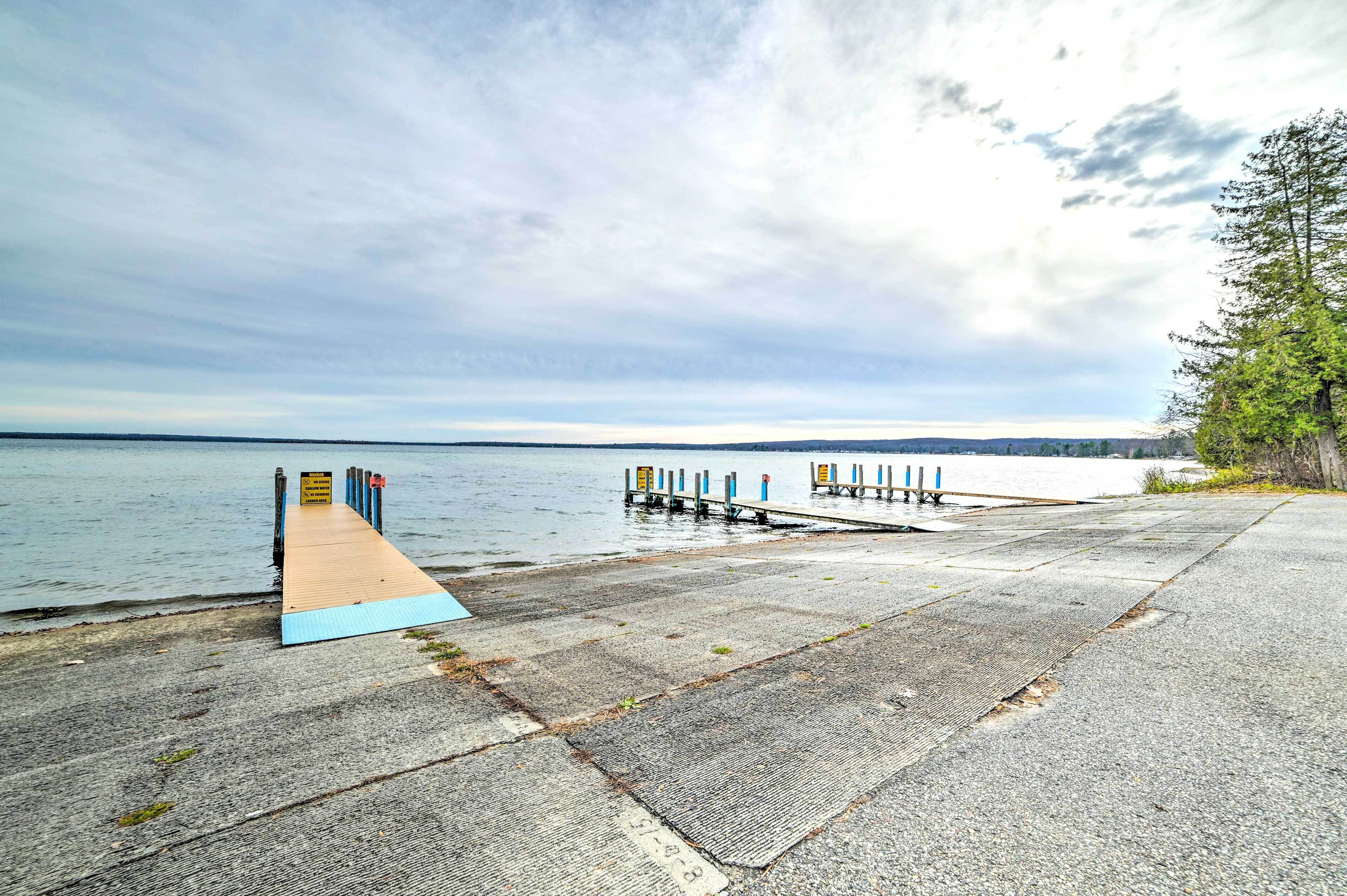 A concrete pier extending into a body of water with a wooden walkway leading to a dock.