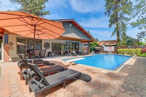 A backyard with a swimming pool, outdoor seating, and a covered patio area. - Spokane Valley Vacation Rental w/ Shared Pool! (Spokane Valley)