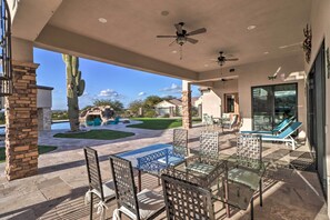 Relax in style with a patio featuring a glass-top table, metal chairs, and a beautiful lawn.
