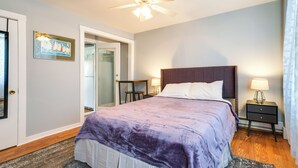 A bedroom with a bed, nightstands, a ceiling fan, and a door leading to another room. - Downtown Hallowell Retreat w/ Water Views! (Hallowell)