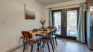 A dining area with a wooden table set for four, chairs, a vase with dried plants, and a painting on the wall. - Chandler Vacation Rental on Route 66, Near Casino (Chandler)