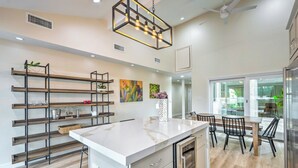 A modern kitchen with a marble island, black chairs, and a dining table. - Luxury Scottsdale Vacation Rental w/ Patio! (Scottsdale)