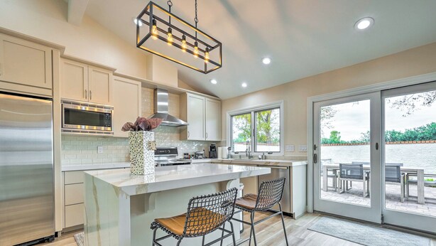 A modern kitchen with a large island, stainless steel appliances, and a view to the outside. - Luxury Scottsdale Vacation Rental w/ Patio! (Scottsdale)