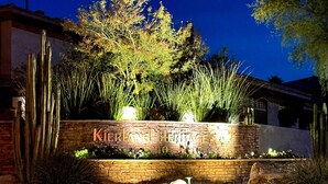 Un mur de pierre portant l’inscription « Kierland Heritage » et le numéro « 5240 », le tout illuminé la nuit.