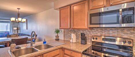 A modern kitchen with wooden cabinets, a stainless steel microwave, and a built-in oven.