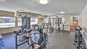 A gym with cardio machines, weight benches, and free weights.