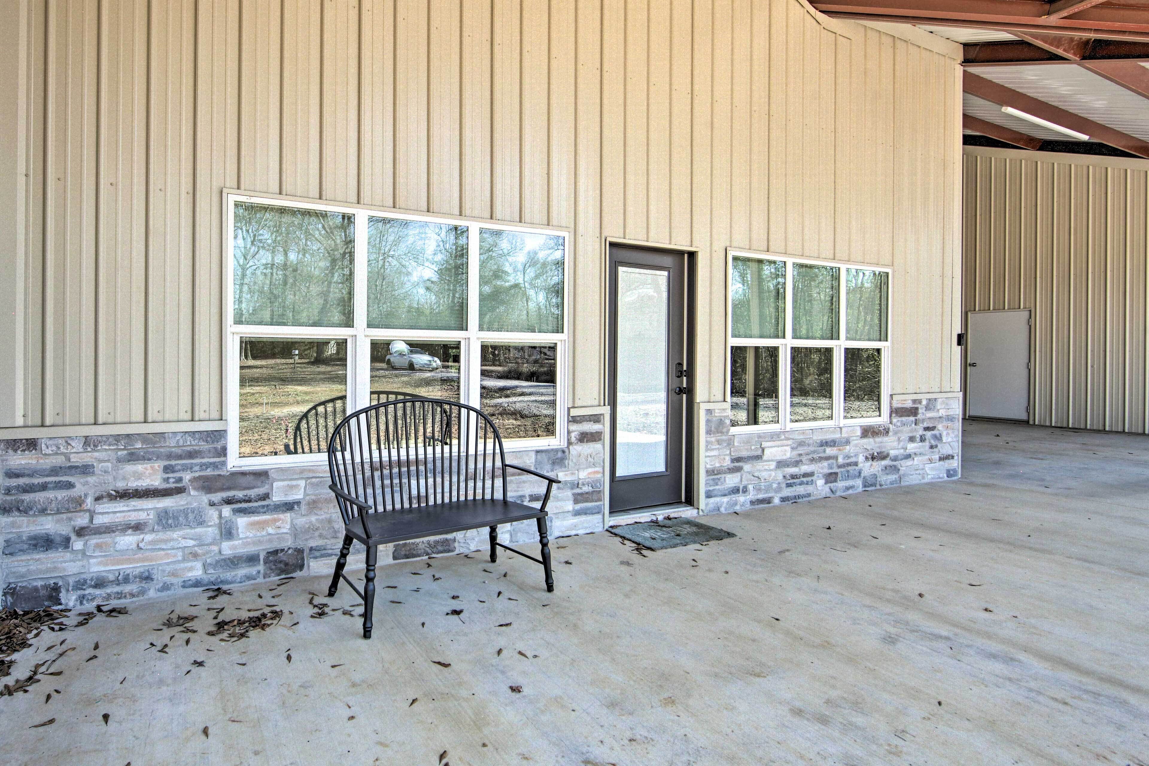 A building with large windows, a bench outside, and a door.