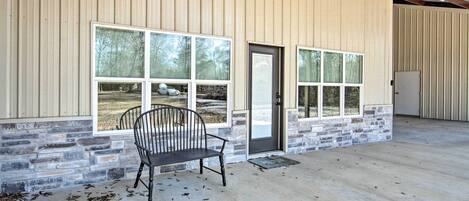 A building with large windows, a bench outside, and a door.