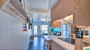 A modern kitchen with a wooden countertop, bar stools, and a built-in stove.