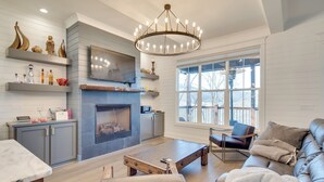 A modern living room with a fireplace, a dining area, and a seating area with a sofa and armchairs. - Fire Pit + Mountain Views! Waynesville Escape (Clyde)