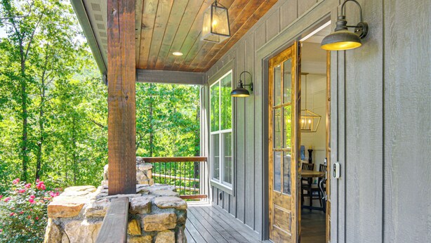 A wooden porch with stone steps, a railing, and a view of a forest. - Fire Pit + Mountain Views! Waynesville Escape (Clyde)