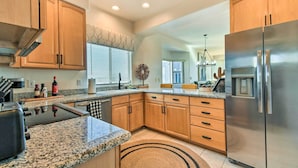 A modern kitchen with granite countertops, wooden cabinets, a stainless steel refrigerator, and a built-in oven. - Pool Access: Mountain-view Condo in Fountain Hills (Fountain Hills)