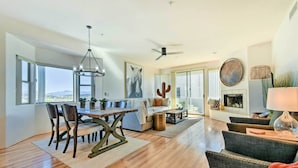 A spacious living area with a dining table, sofas, and a fireplace. - Pool Access: Mountain-view Condo in Fountain Hills (Fountain Hills)