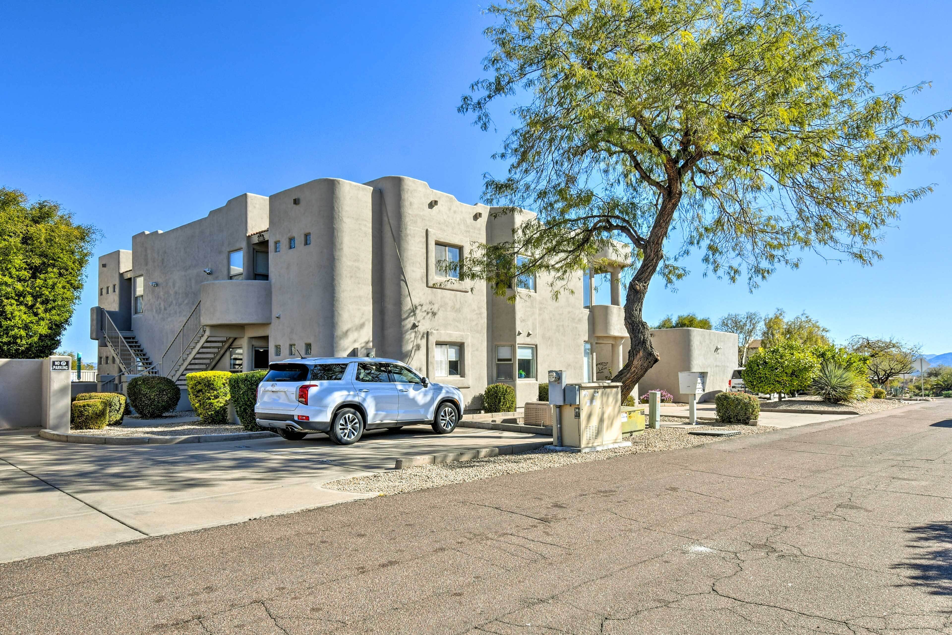 Un edificio moderno con un SUV bianco parcheggiato davanti.