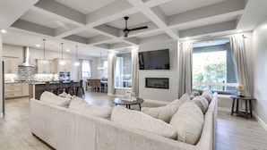 A spacious living area with a large sofa, dining table, and kitchen in the background. - Stunning Grand Junction Home Near Downtown! (Grand Junction)