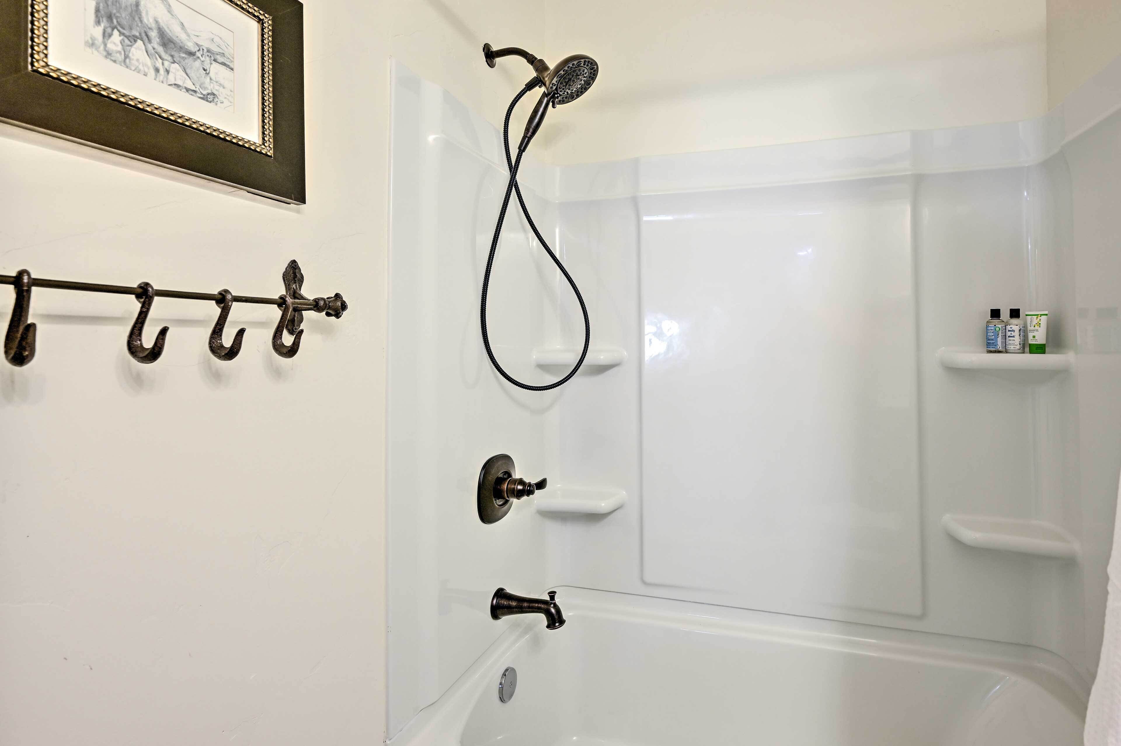 Une salle de bain avec une baignoire, une douche et un porte-serviettes.
