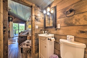 A wooden interior with a sink, toilet, and a mirror. - Rustic Dog-friendly Cabin w/ Deck & Fire Pit! (Murray)