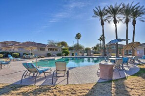 A pool area with lounge chairs, umbrellas, and palm trees. - Walk to Community Pool: Goodyear Desert Oasis (Goodyear)