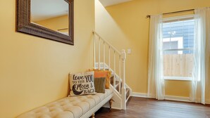A room with a bench, a mirror, a staircase, and a window with curtains. - Chic Indianapolis Home w/ Yard Near Downtown! (Indianapolis)