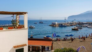 A coastal town with a beach, boats, and a pier. - Leucosia in Sorrento (Sorrento)