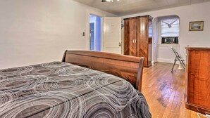 Un dormitorio con cama, armario, ventilador de techo y ventana con persianas.
