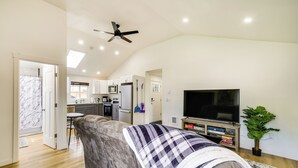 A modern living room with a grey sofa, a flat-screen TV, and a ceiling fan. - Modern Pacific Vacation Rental: 5 Mi to Lake Tapps (Pacific)