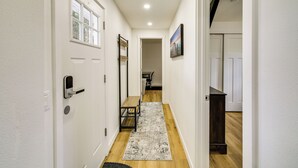 A hallway with white walls, wooden flooring, a bench, and a rug. - Modern Pacific Vacation Rental: 5 Mi to Lake Tapps (Pacific)