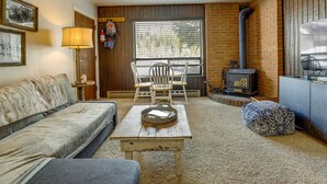 A cozy living room with a sofa, a coffee table, and a fireplace. - Brian Head Vacation Rental w/ On-site Ski Lift! (Brian Head)
