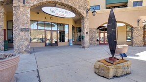 A hotel entrance with a stone facade, a large planter, and a decorative sculpture. - Cozy Avon Condo Near Beaver Creek Resort! (Avon)