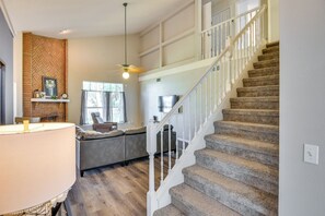 A spacious living area with a staircase, a ceiling fan, and a fireplace. - 7 Mi to Beach: Pet-friendly Home in Port Orange! (Port Orange)
