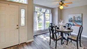 A dining area with a round table, chairs, a ceiling fan, and a painting on the wall. - 7 Mi to Beach: Pet-friendly Home in Port Orange! (Port Orange)