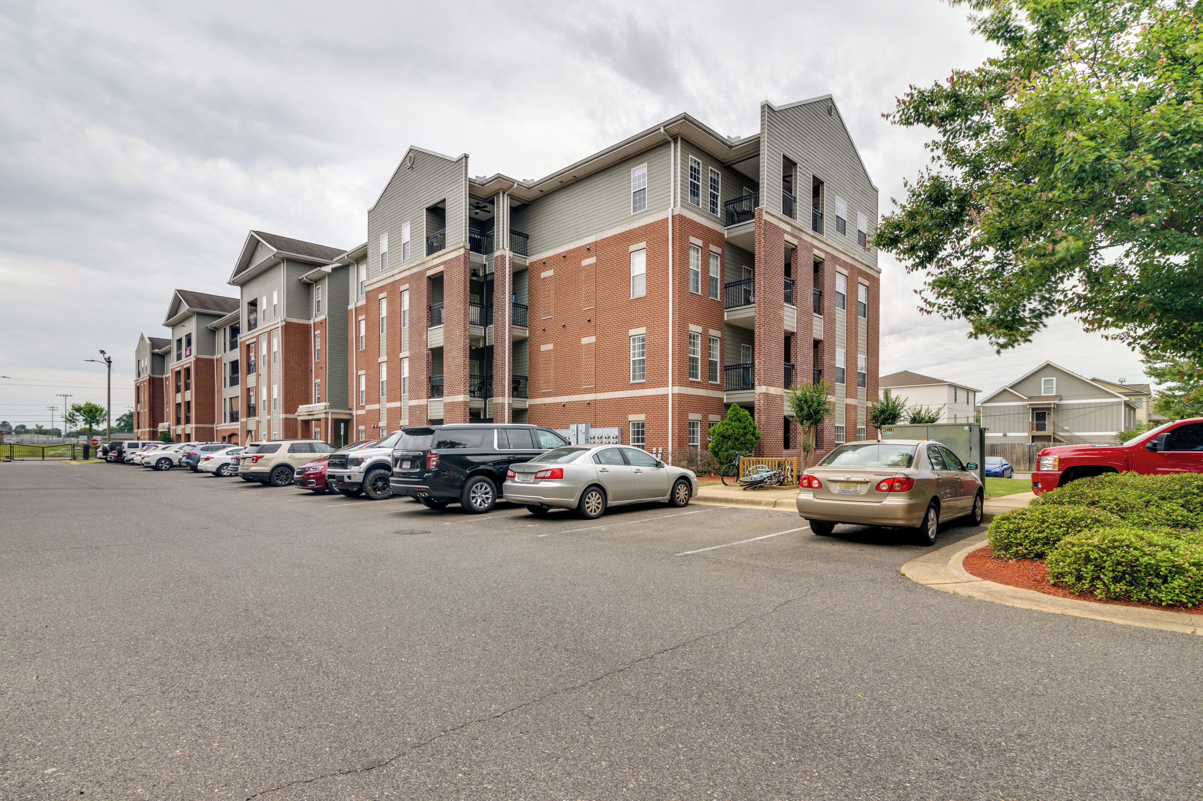 A multi-story apartment building with a parking lot in front.