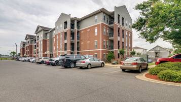 A multi-story apartment building with a parking lot in front.