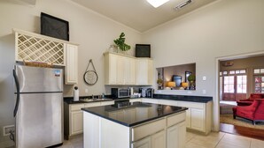 Una cocina moderna con una isla central, electrodomésticos de acero inoxidable y armarios blancos.