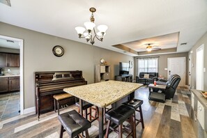 Un salon spacieux avec une grande table à manger, un piano et un coin salon confortable.