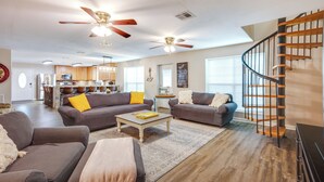 A spacious living area with two sofas, a coffee table, and a staircase with a wooden railing. - Point Blank Vacation Rental w/ Large Patio! (Pointblank)