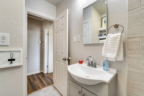 A bathroom with a white sink, a mirror, and a towel ring.