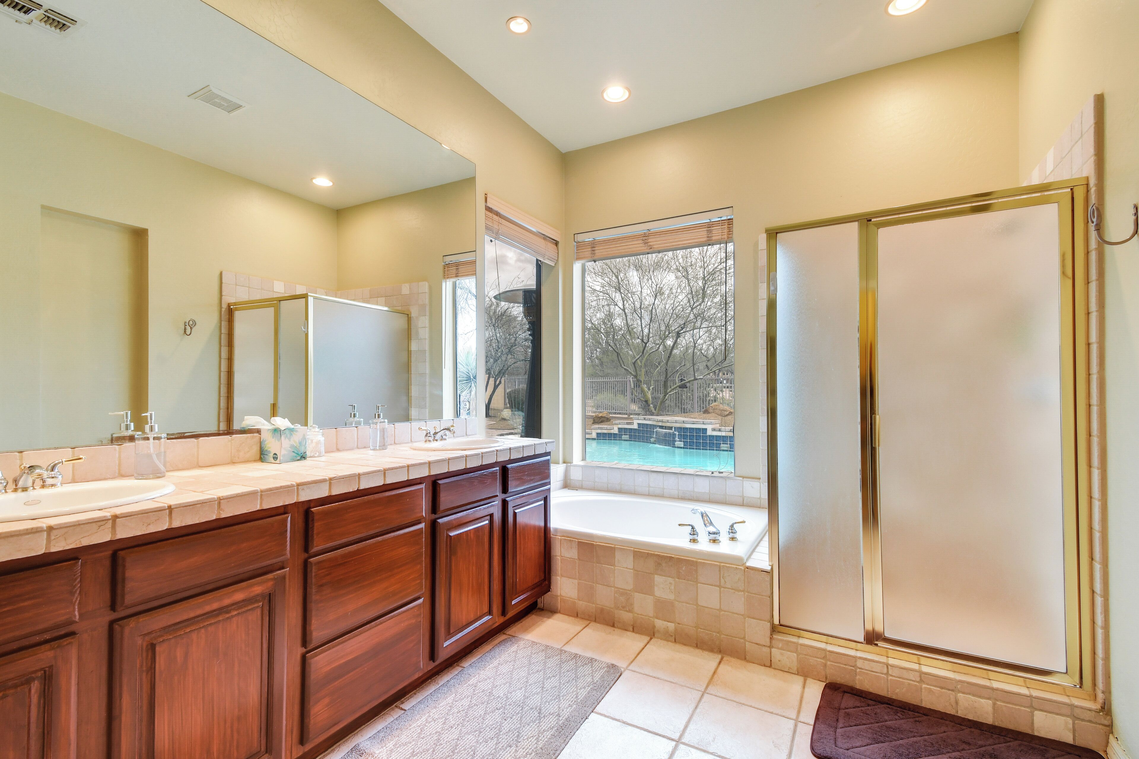 A modern bathroom with a large vanity, a bathtub, and a shower enclosure.