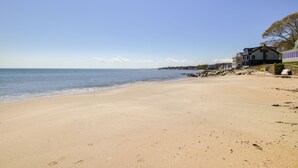Una spiaggia con una casa sulla destra.