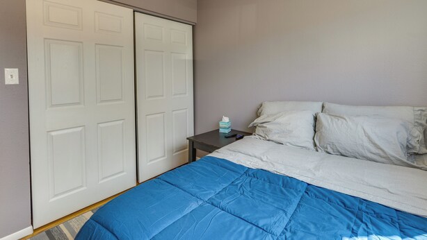 Una camera da letto con un letto, un comodino e un armadio.