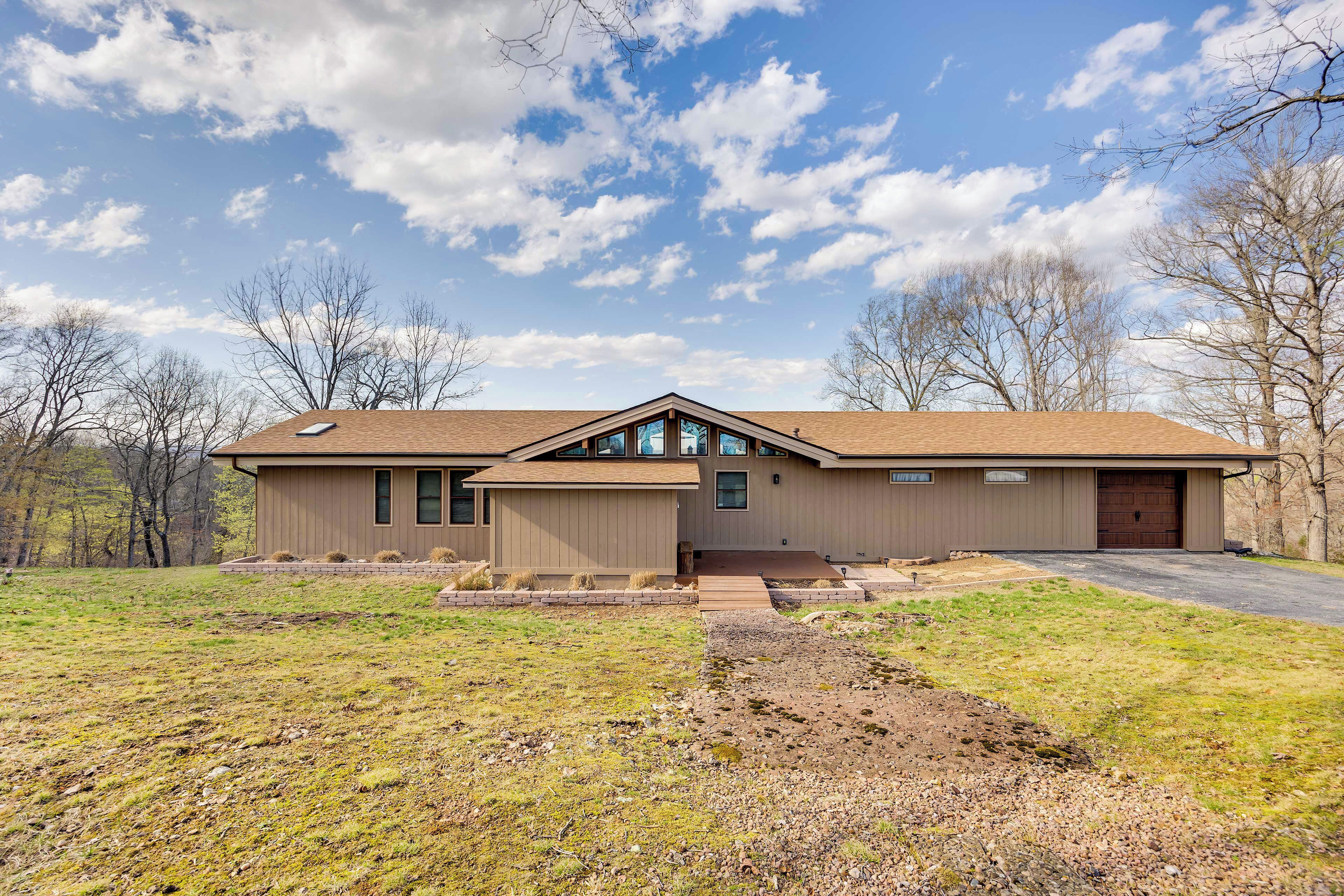 A modern two-story house with a large garage, a covered front porch, and a well-maintained lawn.