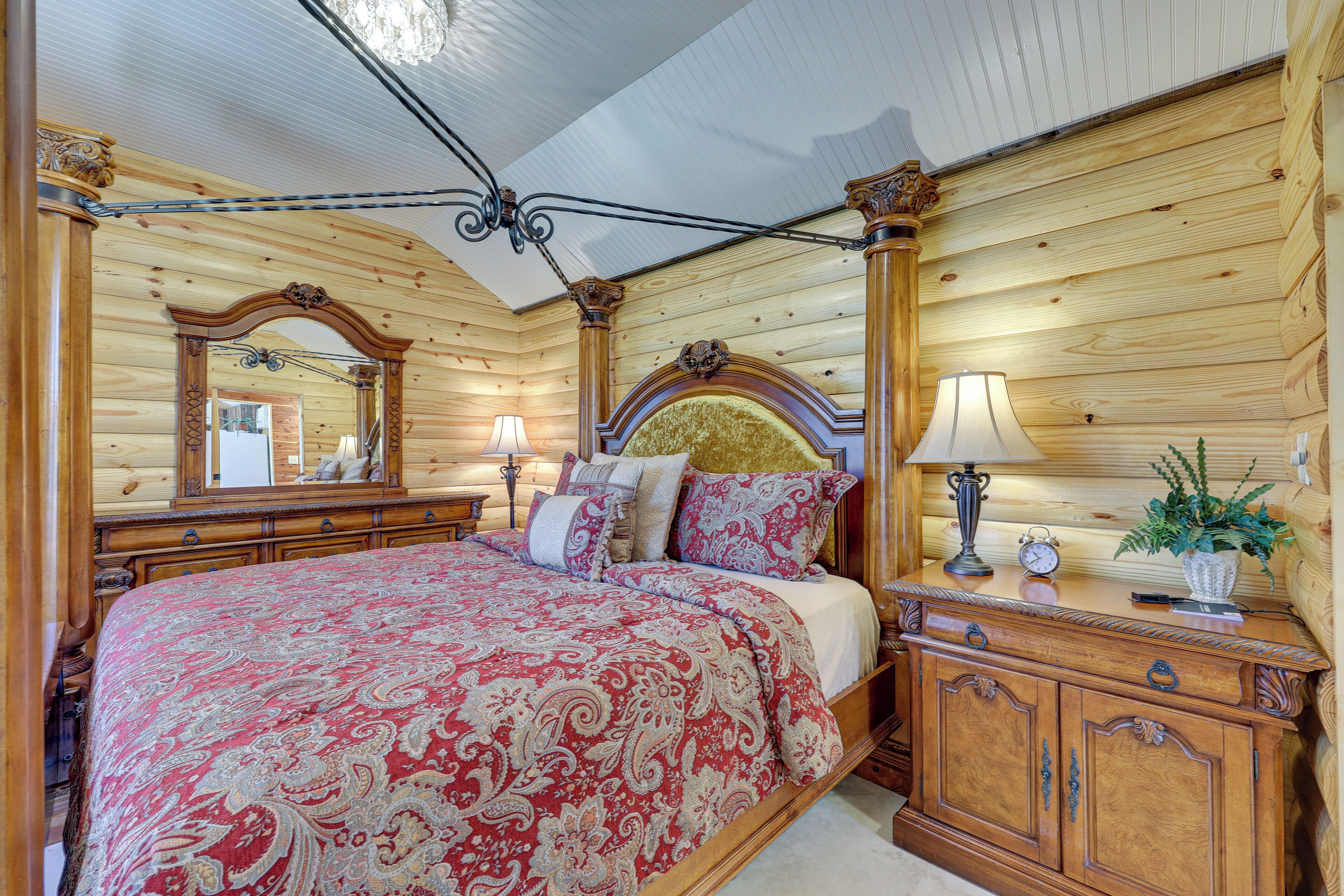 A wooden bedroom with a four-poster bed, a nightstand, and a dresser.