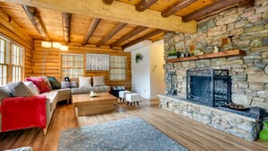A cozy log cabin interior with a stone fireplace, wooden beams, and a comfortable seating area. - Pine Mountain Club Cabin w/ Community Pool! (Pine Mountain Club)