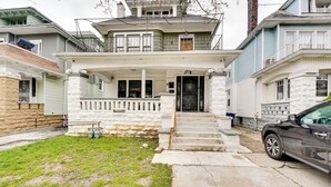A two-story house with a front porch, a driveway, and a parked car. - Buffalo Vacation Rental ~ 20 Mi to Niagara Falls! (Buffalo)