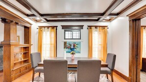 A dining area with a wooden table, two chairs, a vase with flowers, and a painting on the wall. - Buffalo Vacation Rental ~ 20 Mi to Niagara Falls! (Buffalo)