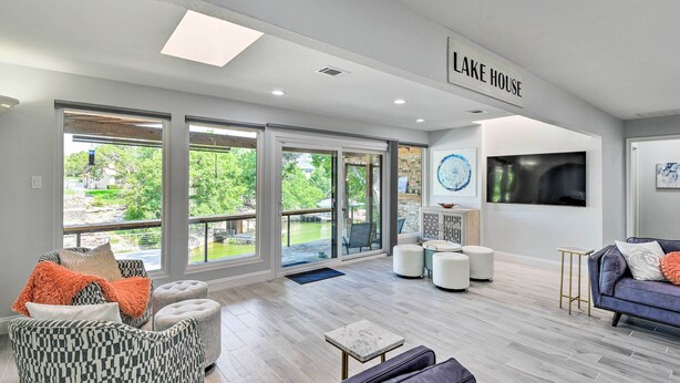 A spacious living room with large windows, a fireplace, and a sign reading "LAKE HOUSE". - Luxury Granbury Home w/ Private Boat Dock! (Granbury)